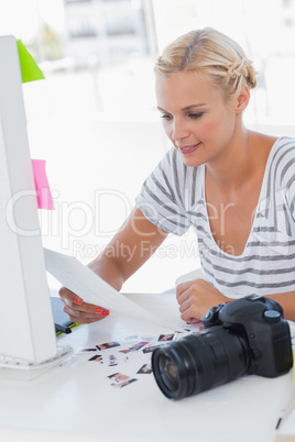 Cheerful photo editor looking at a contact sheet