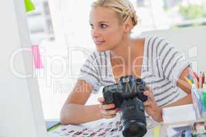 Pretty photo editor looking at a digital camera