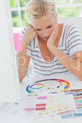 Thoughtful interior designer looking at a colour wheel