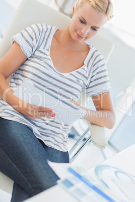 Blonde designer working on a tablet computer