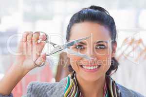 Cheerful designer holding scissors