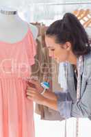 Pretty fashion designer fixing dress