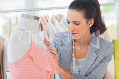 Fashion designer measuring dress in a studio