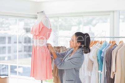 Pretty fashion designer adjusting dress