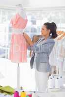 Fashion designer measuring dress with a measuring tape