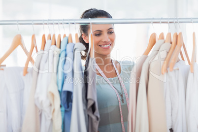 Attractive fashion designer looking at clothes
