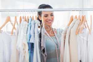 Attractive fashion designer looking at clothes