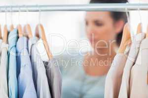 Fashion woman choosing clothes on clothes rail