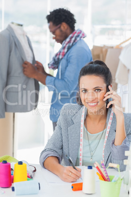 Smiling fashion designer calling