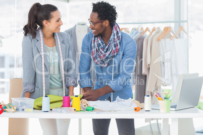 Smiling fashion designers working together