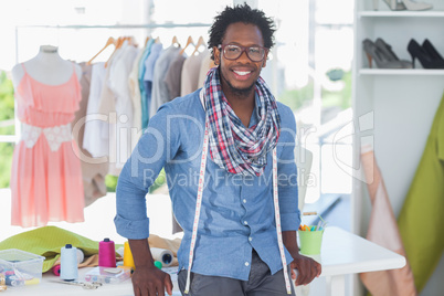 Handsome fashion designer leaning on desk