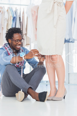 Attractive fashion designer fixing needles on dress