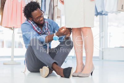 Fashion designer sitting and adjusting dress