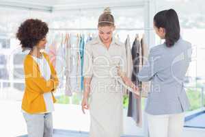 Fashion designers looking at model