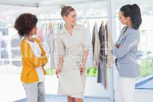 Two fashion designers looking at model
