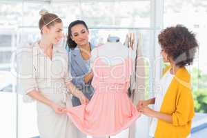 Fashion designers looking at a dress
