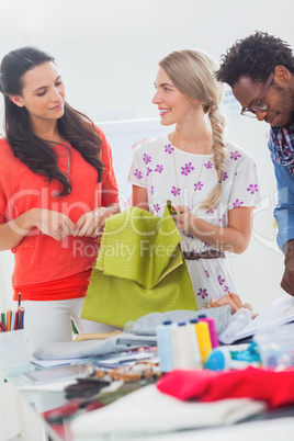 Three fashion designers holding textile