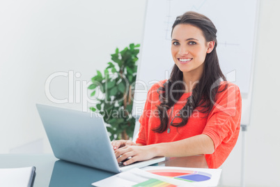 Cheerful designer working on her laptop