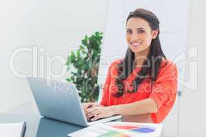 Cheerful designer working on her laptop