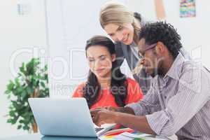 Three designers working together on a laptop