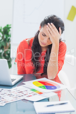 Annoyed designer sitting behind her desk