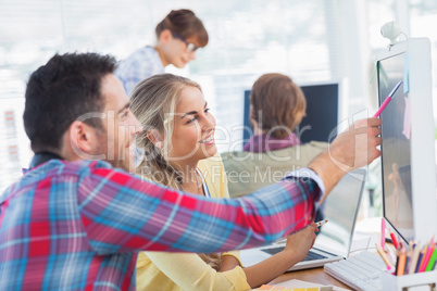 Designer pointing at the screen of a colleague