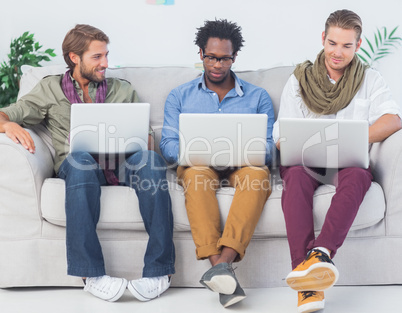 Male designers working together with laptops