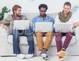 Male designers working together with laptops