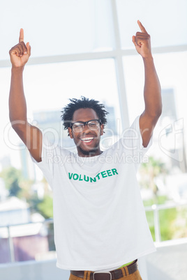 Cheerful man with volunteer tshirt raising his arms