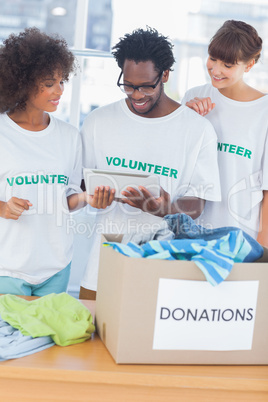 Cheerful volunteers looking at a tablet pc