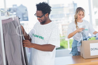 Volunteers taking clothes out of a donation box