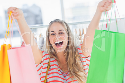 Blonde woman raising shopping bags