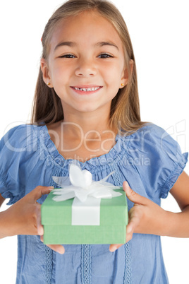 Cheerful little girl holding a wrapped gift