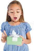 Surprised little girl holding a wrapped gift