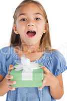 Excited little girl holding a wrapped gift