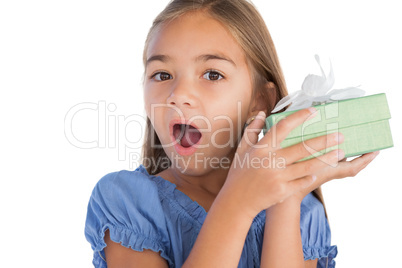 Smiling girl astonished while holding a present Smiling girl astonished while holding a present