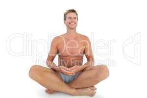 Shirtless man with eyes closed meditating