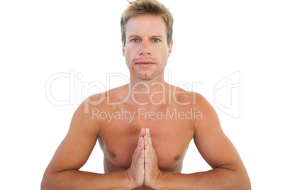 Shirtless man doing yoga and meditating