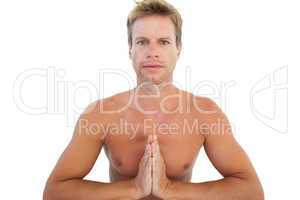 Shirtless man doing yoga and meditating