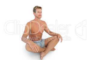 Handsome man doing yoga and sitting in lotus position