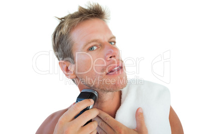 Shirtless man shaving his beard