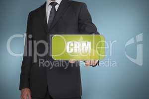 Businessman touching green tag with the word crm written on it