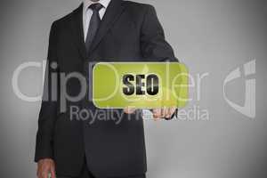 Businessman selecting green tag with the word seo written on it