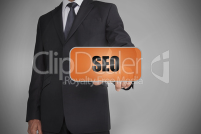 Businessman touching orange tag with the word seo written on it