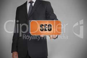 Businessman touching orange tag with the word seo written on it