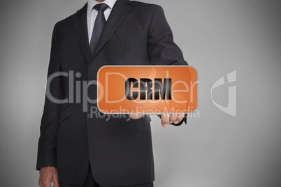 Businessman touching orange tag with the word crm written on it