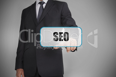 Businessman touching white tag with the word seo written on it