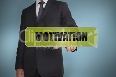 Businessman touching the word motivation written on green tag