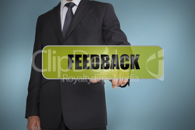 Businessman touching the word feedback written on green tag