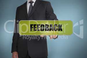 Businessman touching the word feedback written on green tag